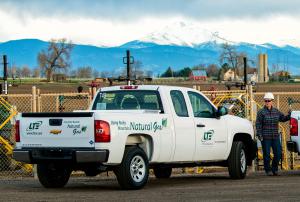 Staff biologist Stacey Baum stands with one of nearly 20 vehicles in the LT Environmental fleet that now runs on Colorado natural gas. (Photo by Todd Warnke)