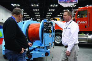 Dean Peake, regional sales manager with Hi-Vac, points out some of the features on the OBrien 7040-SC diesel-powered hydrojetters hydraulically actuated reel. The unit features variable-speed control on an easy-to-use control panel. (Photo by Craig Mandli)