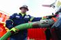 Mustang Oilfield Services employee Ben Stoneking attaches the hose from a frac water tank to his truck to load water.
